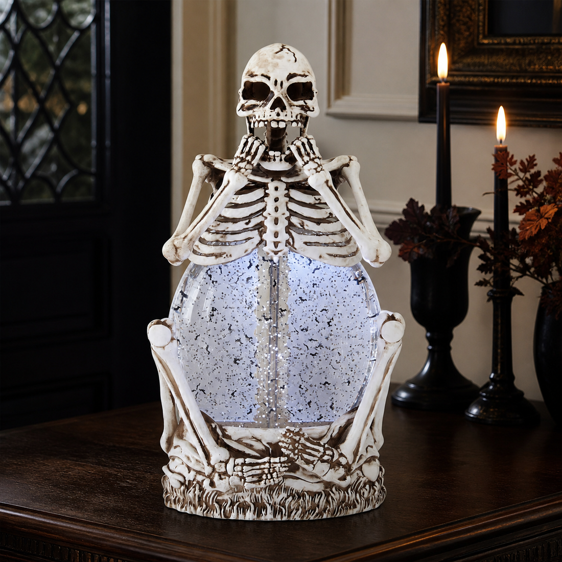 LED spinning skeleton Halloween water globe displayed on a dark wood entryway table