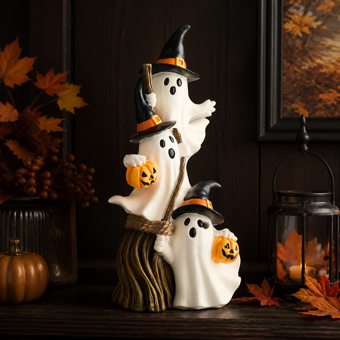 Three stacked ghosts with witch hats and broom styled on a Halloween console
